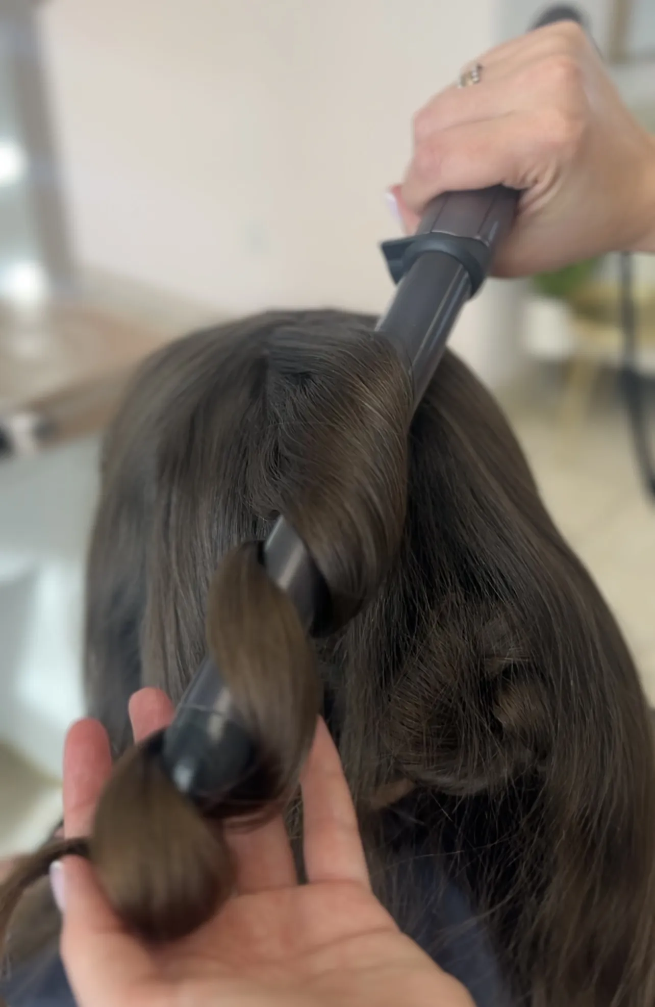 Curling wand creates glossy waves in long brunette hair during a styling session at My Beauty Space Mississauga.