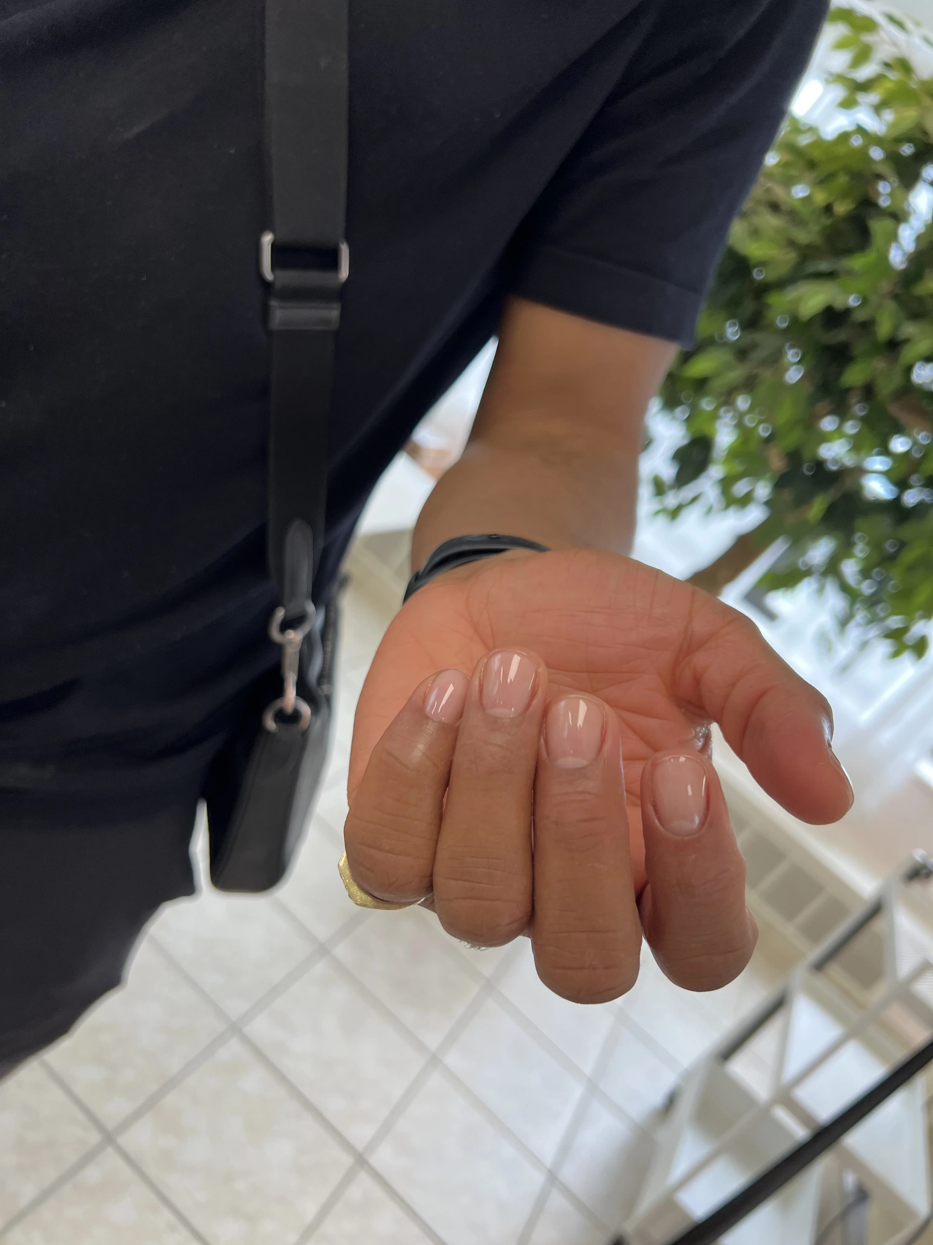 Men's manicure with short clear-gloss nails, gold pinky ring and black watch, at My Beauty Space salon in Mississauga.