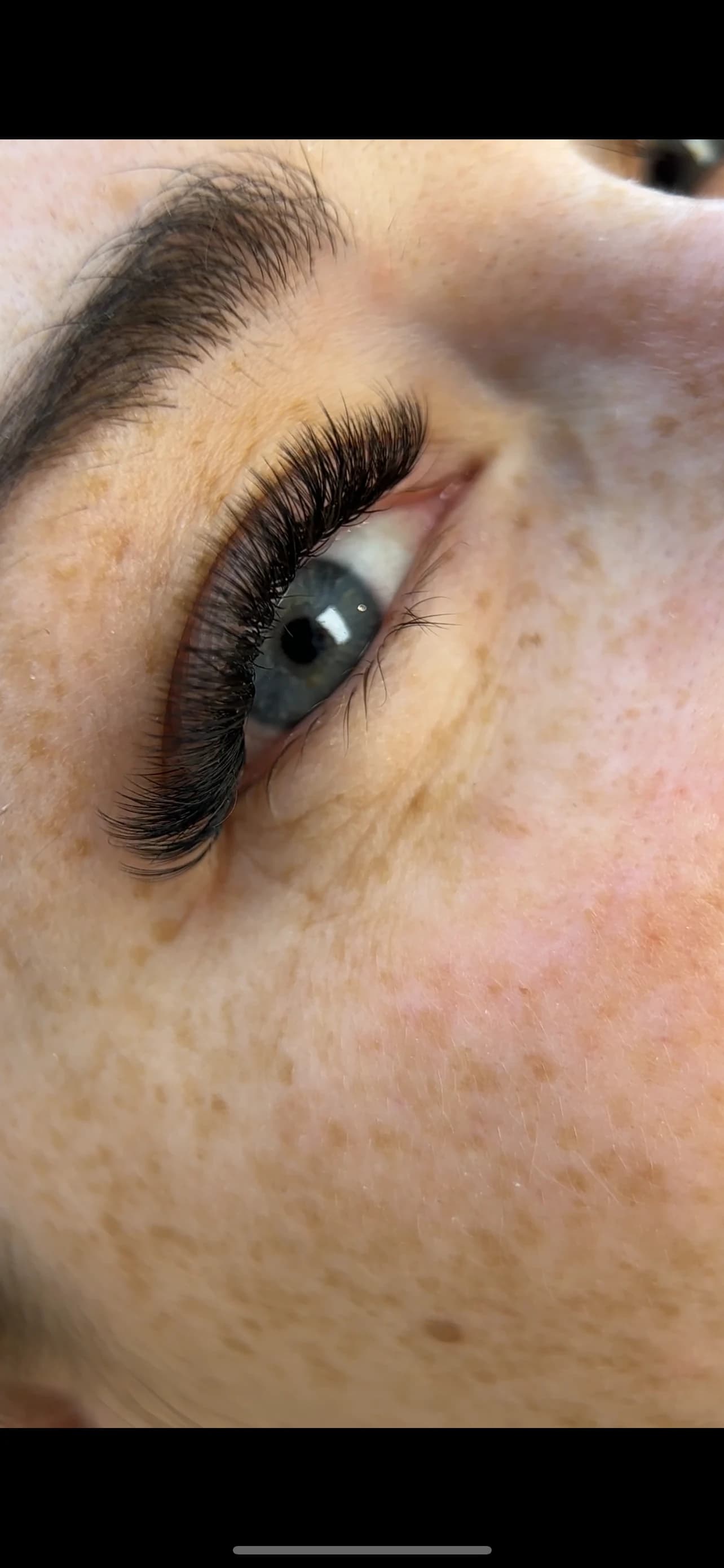 Freckled fair skin frames blue-grey eyes with plush 3D volume lash fans and a groomed arch at My Beauty Space.