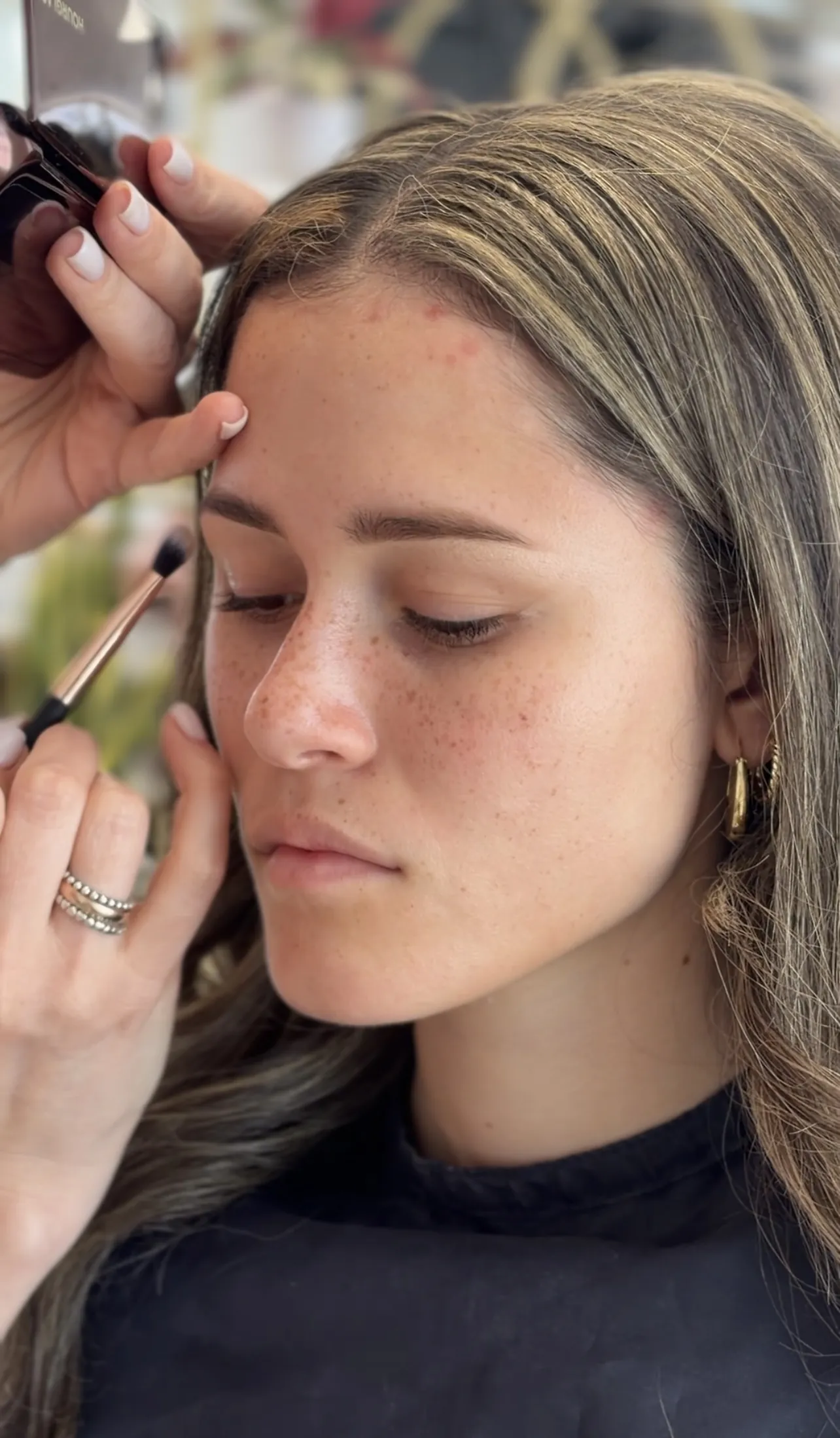 Freckled client receives soft eyeshadow blending with a rose-gold brush during makeup at My Beauty Space Mississauga.
